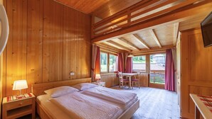 Une pièce dans une cabane en bois, comprenant un lit, une table et une chaise.