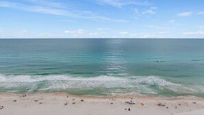 A beach with clear water, a sandy shore, and a few people.