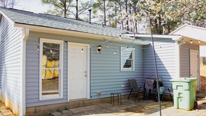 A small, single-story house with a covered patio area. - Spacious Raleigh Retreat | Near Downtown + I-440 (Raleigh)