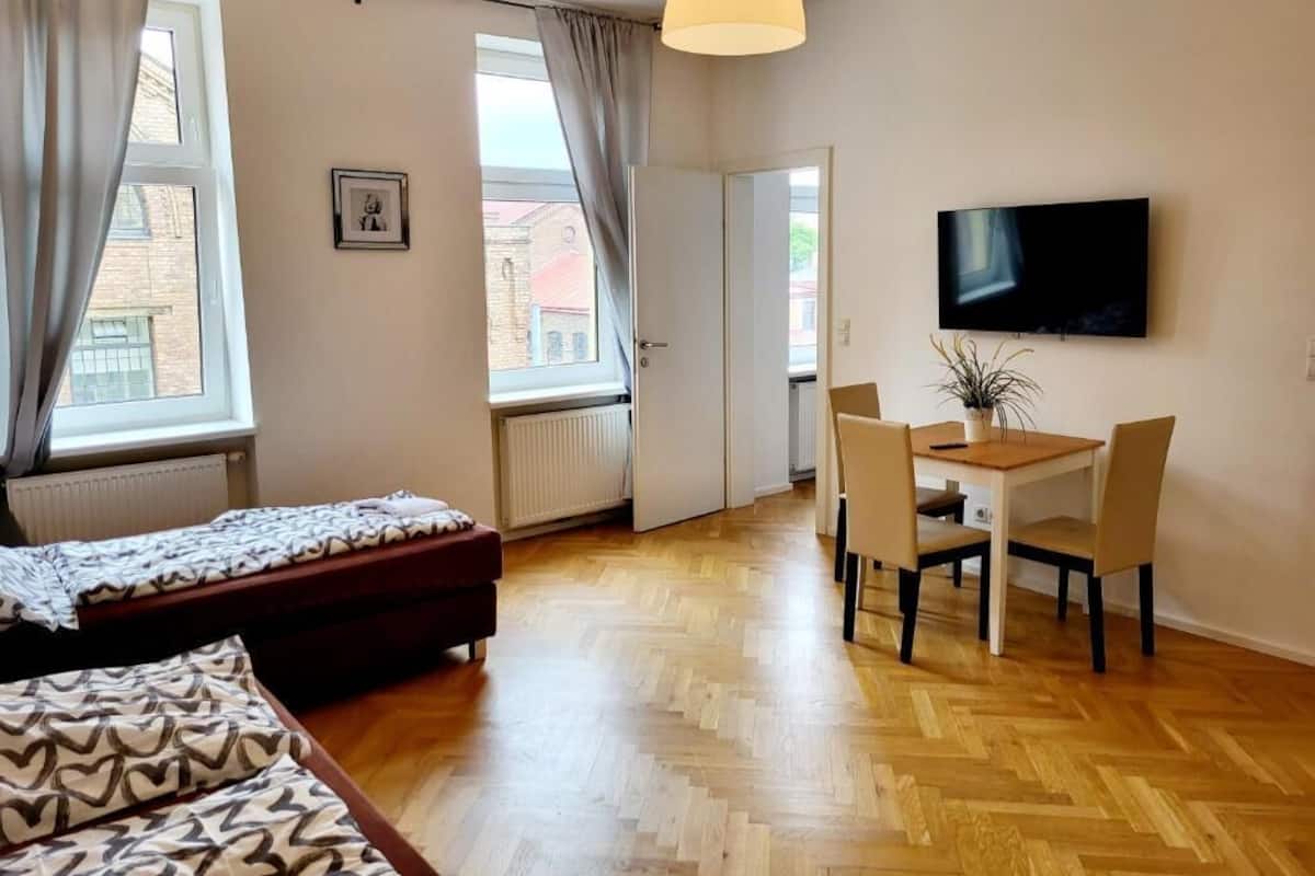 A hotel room with a bed, a desk, and a TV.