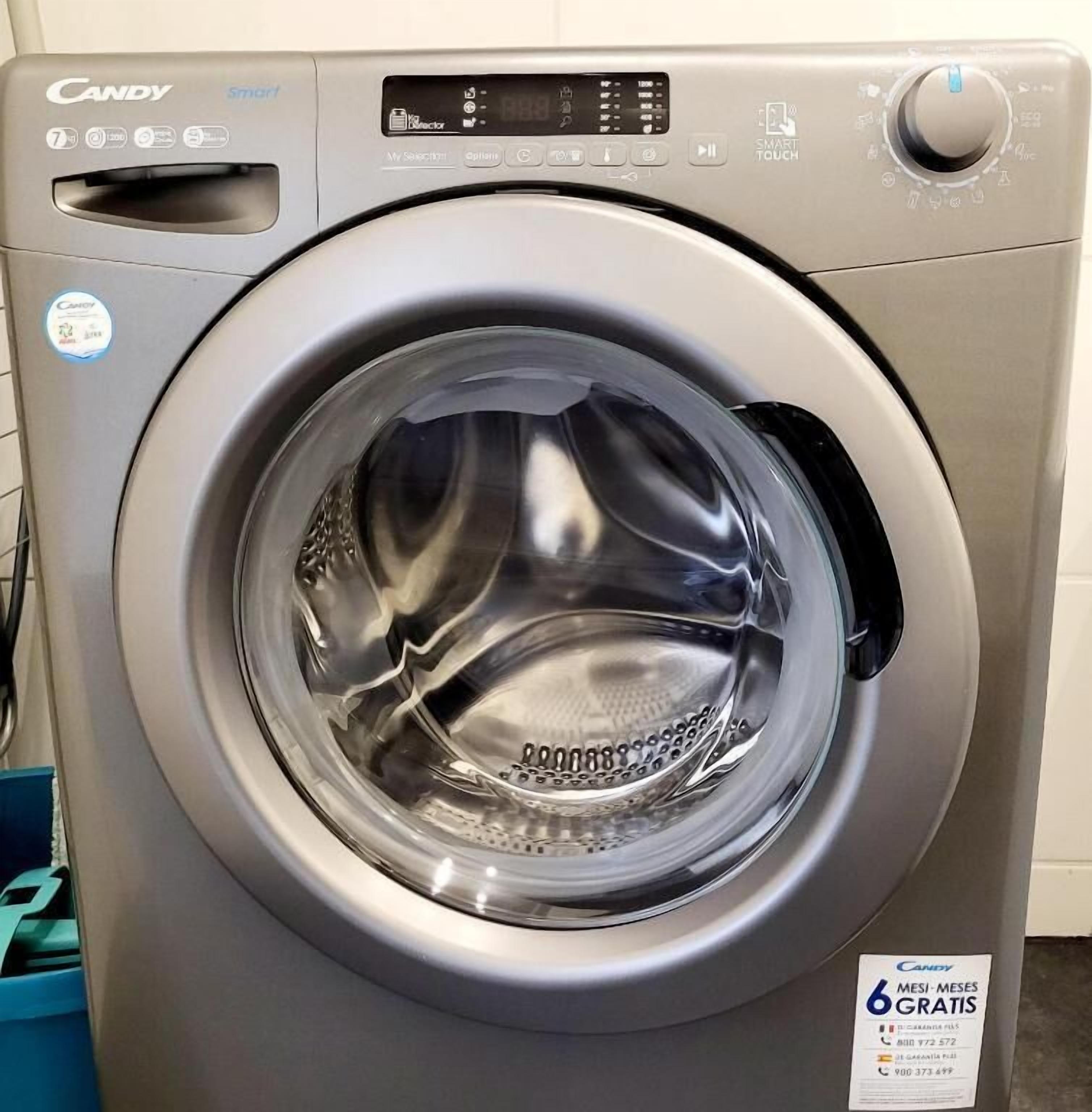 A front view of a Candy SmartTouch washing machine with a digital display and a control knob.