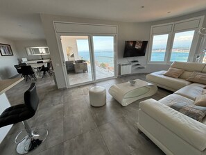 Relax in style with a spacious living room featuring a curved sofa, glass coffee table, and flat-screen TV.