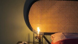 A bedroom with a bed, a reading lamp, and a book on a nightstand. - London Oasis - 2 Bedroom Apartment (London)