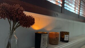 A shelf with candles and a vase of dried flowers. - London Oasis - 2 Bedroom Apartment (London)
