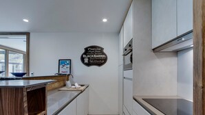 Eine moderne Küche mit weißen Schränken, einer Holz Arbeitsplatte und einer Edelstahl-Dunstabzugshaube.