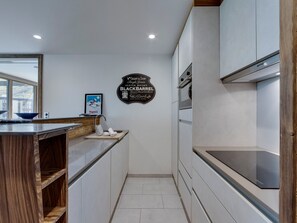 A modern kitchen with white cabinetry, a wooden countertop, and a stainless steel range hood. - Charming renovated 2BR, ski-in/ski-out, Val Claret, 5-6 pax, WiFi included (Tignes)