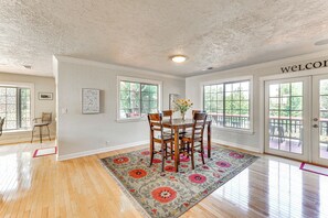 A dining area with a wooden table and chairs, a floral rug, and a 'WELCOME' sign on the wall. - 8 Mi to Jacksonville: Oregon Getaway w/ Deck! (Jacksonville)
