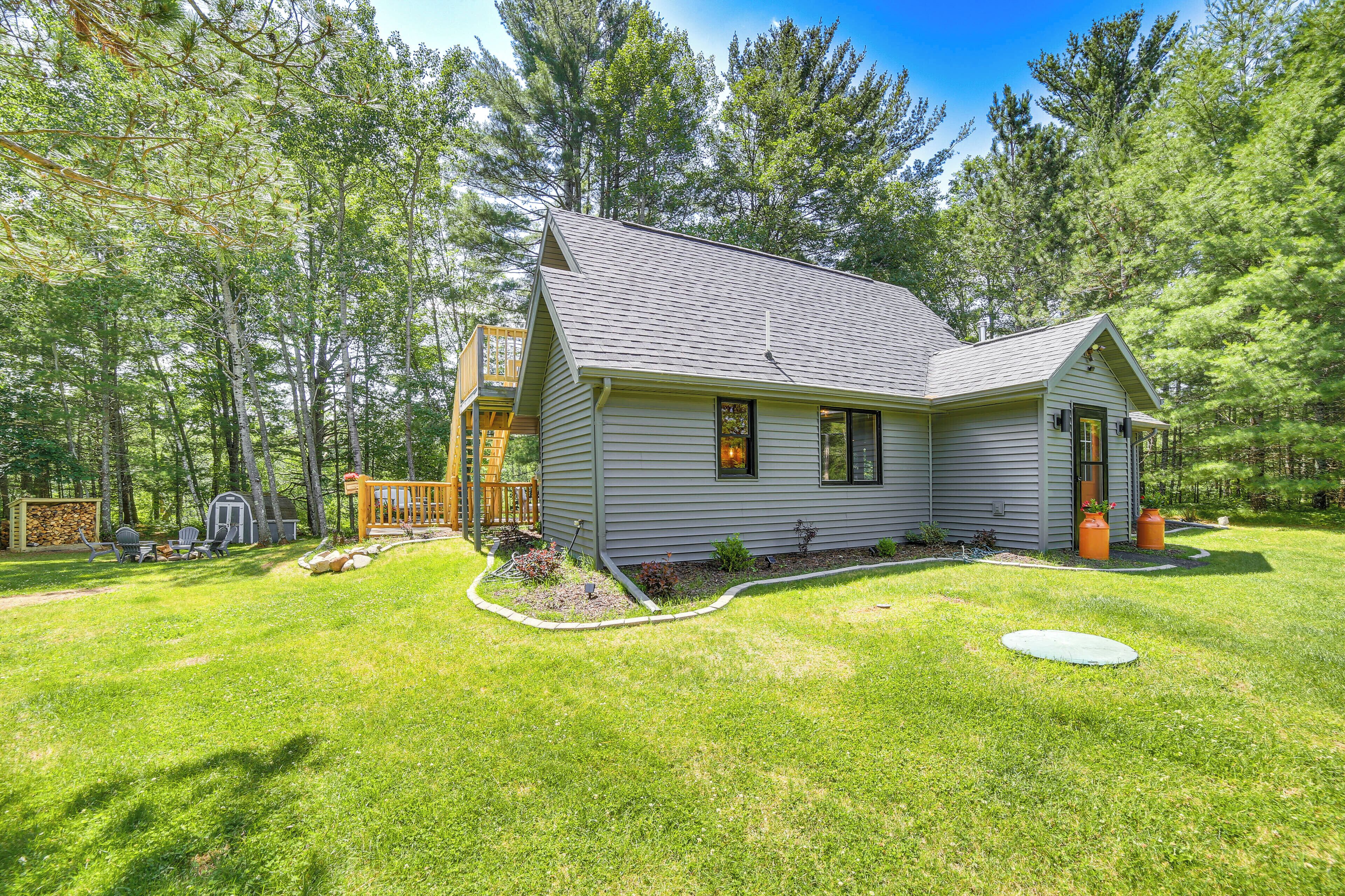 A single-story house with a covered porch, a small deck, and a well-maintained lawn.
