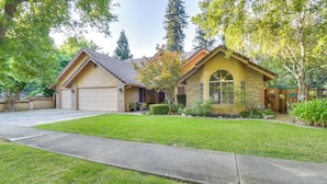 A two-story house with a garage, a well-maintained lawn, and mature trees. - 1 Mi to Applegate Park Zoo: Pet-friendly Home (Merced)