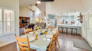 A dining area with a table set for six, wooden chairs, and a ceiling fan. - 1 Mi to Applegate Park Zoo: Pet-friendly Home (Merced)