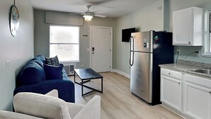A compact living space with a kitchenette, a ceiling fan, a sofa, and a dining table. - PC Beach Retreat A | 0.5mi to Beach, Outdoor Showers, Shard Yard (Panama City Beach)
