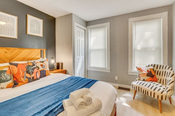 A bedroom with a bed, a chair, and two windows with blinds. - University of Akron Retreat: Dogs Welcome! (Akron)