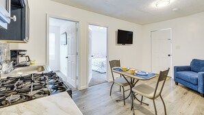 A kitchen with a gas stove, a sink, and a dining area with a table and chairs. - Walkable Barberton Apartment: 9 Mi to Akron! (Barberton)