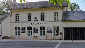 Ein zweistöckiges Gebäude mit der Aufschrift 'LA GARE' und 'Robert Doisneau' an der Fassade.