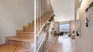 A staircase with a railing, a dining area with chairs and a table, and a view of the outdoors. - Holiday Home 'Casa Di Tino' with Lake View, Wi-Fi and Air Conditioning (Brenzone sul Garda)