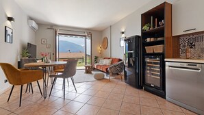 A modern kitchen with a dining area, a sofa, and a view of the outdoors. - Holiday Home 'Casa Di Tino' with Lake View, Wi-Fi and Air Conditioning (Brenzone sul Garda)