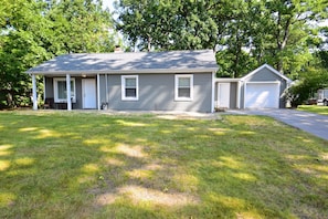 A two-story house with a front porch, a garage, and a well-maintained lawn.