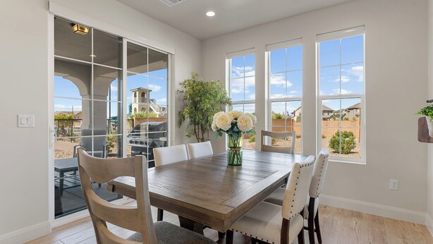 A dining area with a wooden table and chairs, a vase with flowers, and large windows with a view of a residential area. - The One by the Pool: Waterslide, Lazy River, Pickleball, Shuffleboard! (Washington)