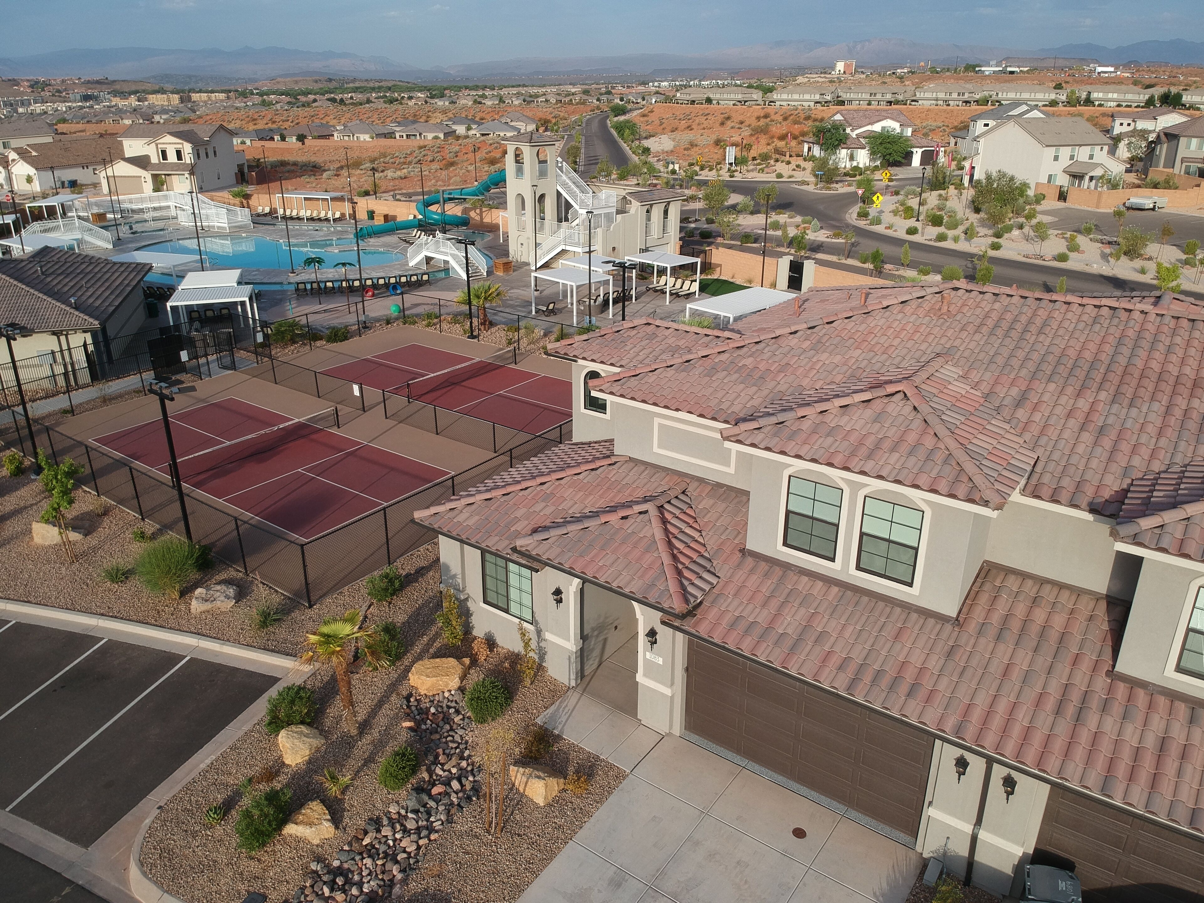 A residential area with houses, a swimming pool, and a tennis court.