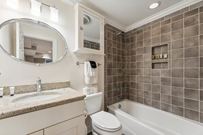 A bathroom with a sink, toilet, and bathtub. - West Taylor Garden Retreat (Savannah)