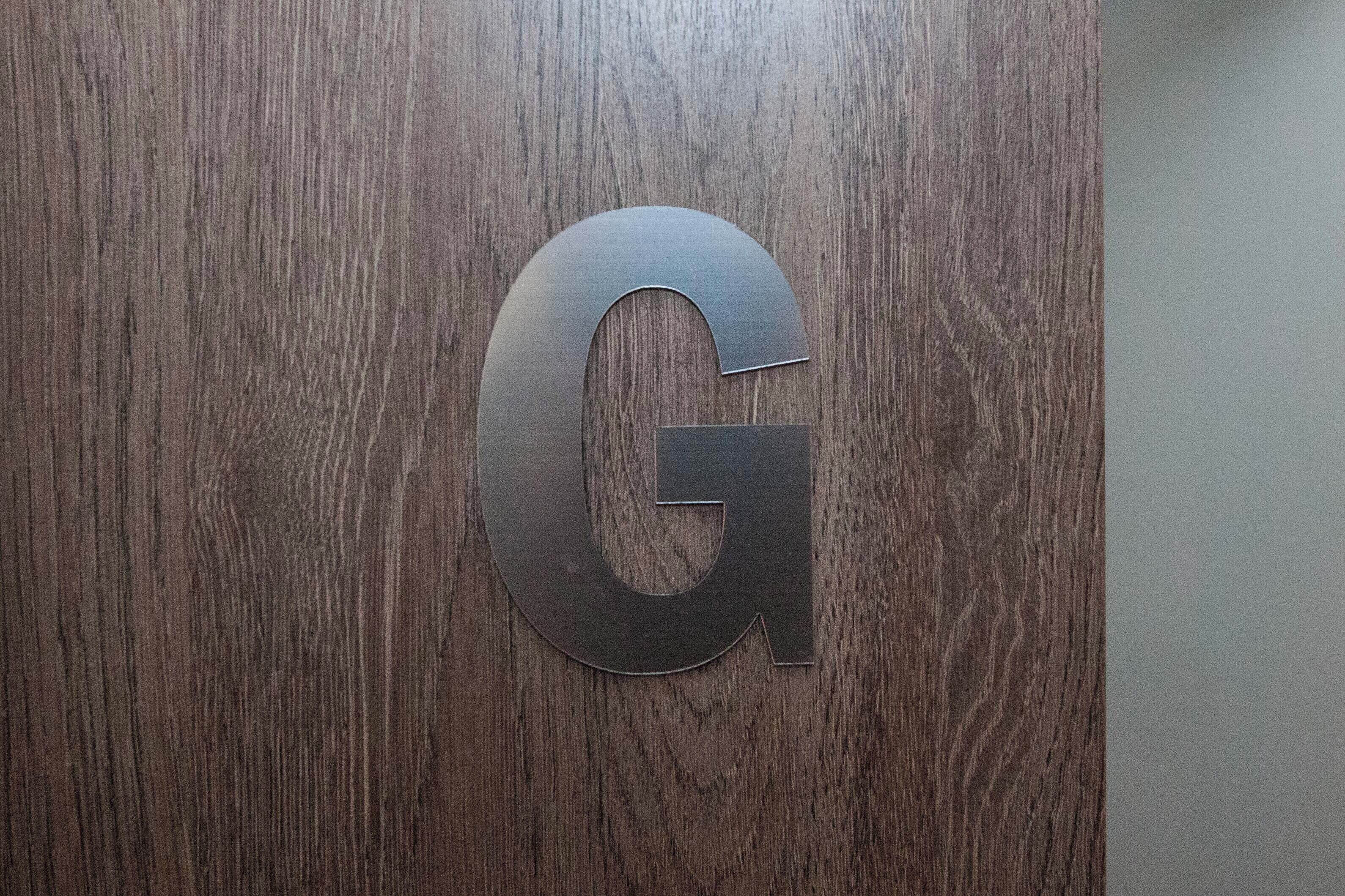 A wooden surface with a large, metallic letter 'G'.