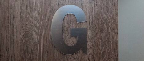 A wooden surface with a large, metallic letter 'G'.