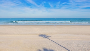 A beach with a clear sky and calm sea.