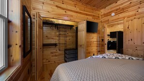 A wooden cabin room with a bed, a television, and a small kitchenette. - Otsego Lake Access Cabin, Fire Pit, Backyard & BBQ (Gaylord)