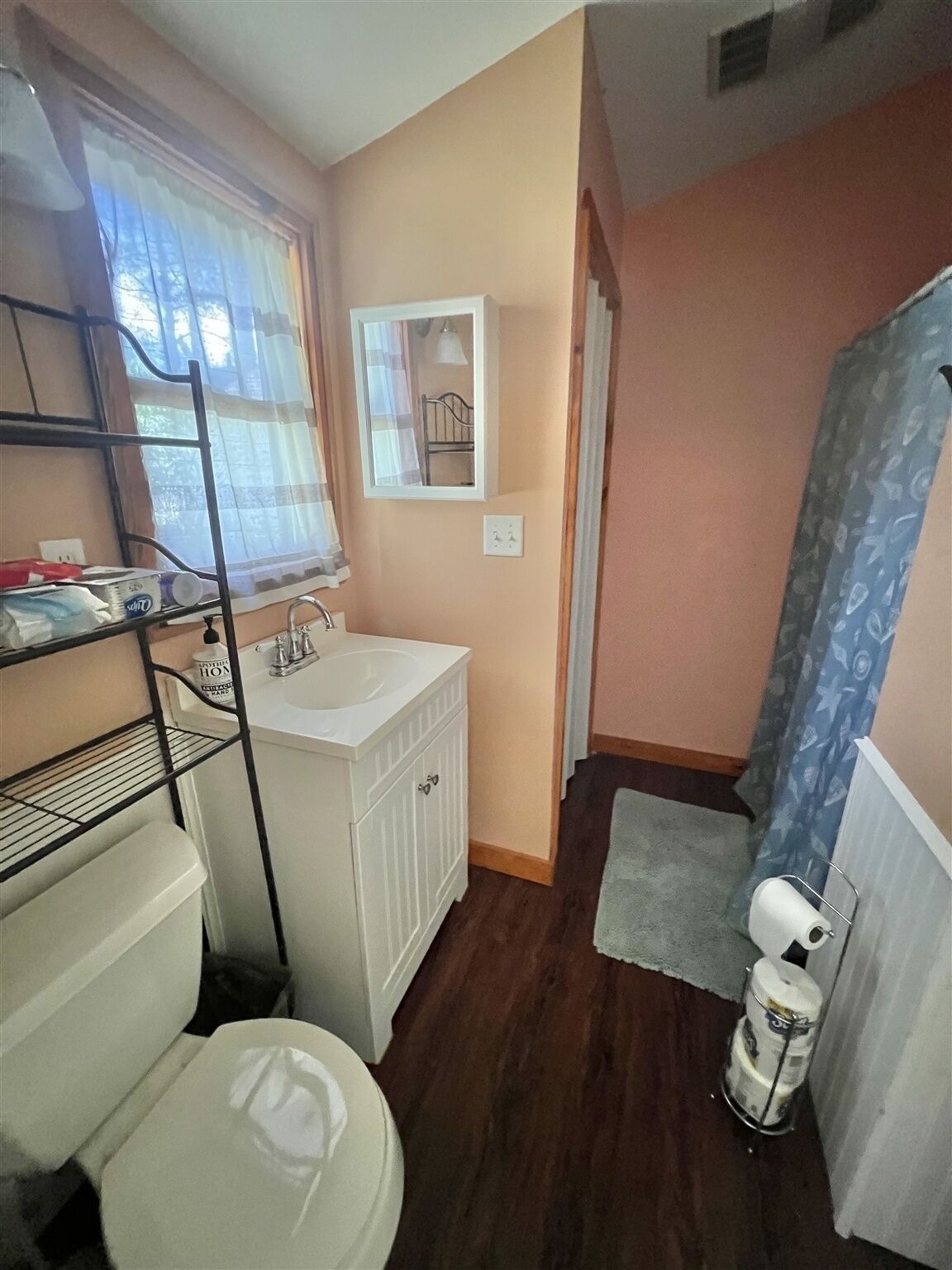 Casa de banho compacta com lavatório branco, sanita e zona de duche.