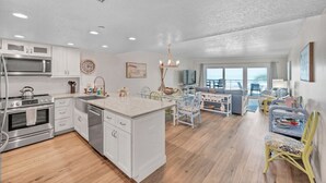 Une cuisine moderne avec des meubles blancs, des appareils en acier inoxydable et un îlot central.