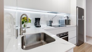 A modern kitchen with a stainless steel sink, a coffee maker, a microwave, and a refrigerator. - Apartment 'El Corazon De Aguilas' with Wi-Fi and Air Conditioning (Águilas)