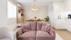 A modern living room with a sectional sofa, a dining table with chairs, a pendant light, and a kitchen area with a sink and countertop. - Apartment 'El Corazon De Aguilas' with Wi-Fi and Air Conditioning (Águilas)