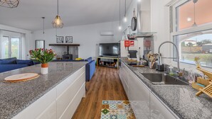 Una cocina moderna con encimeras de granito, horno empotrado y un amplio ventanal.