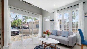 A modern living room with a grey sofa, a white coffee table, and a blue chair.