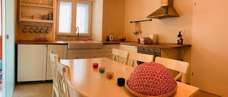 A kitchen with white cabinets, a wooden countertop, a sink, and a window.