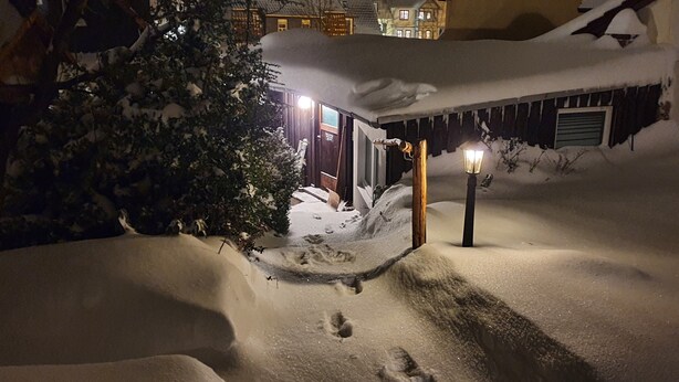 A snow-covered outdoor area with a wooden structure, a lamp post, and a tree. - Ferienwohnung Fliegenpilz - 50m² OG1 (Quedlinburg)