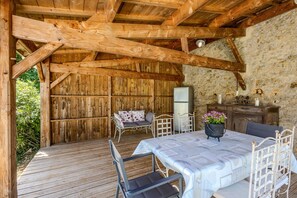 A rustic wooden room with a bed, a table, and chairs.