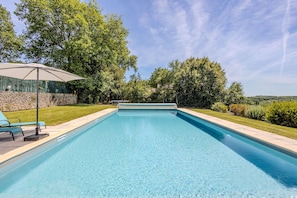 A rectangular swimming pool with a clear blue water surface, surrounded by a stone wall and lush greenery. - Villa Le Bos - Three Bedroom Villa, Sleeps 6 (Pezuls)