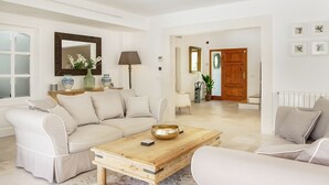 Ein geräumiges Wohnzimmer mit einem beigefarbenen Sofa, einem Holztisch und einem großen Spiegel.