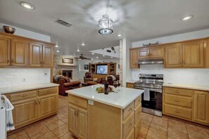 Una cocina amplia con armarios de madera, una isla central y un horno empotrado.