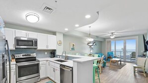 Una cocina moderna con electrodomésticos de acero inoxidable, una isla central y un comedor con vistas.