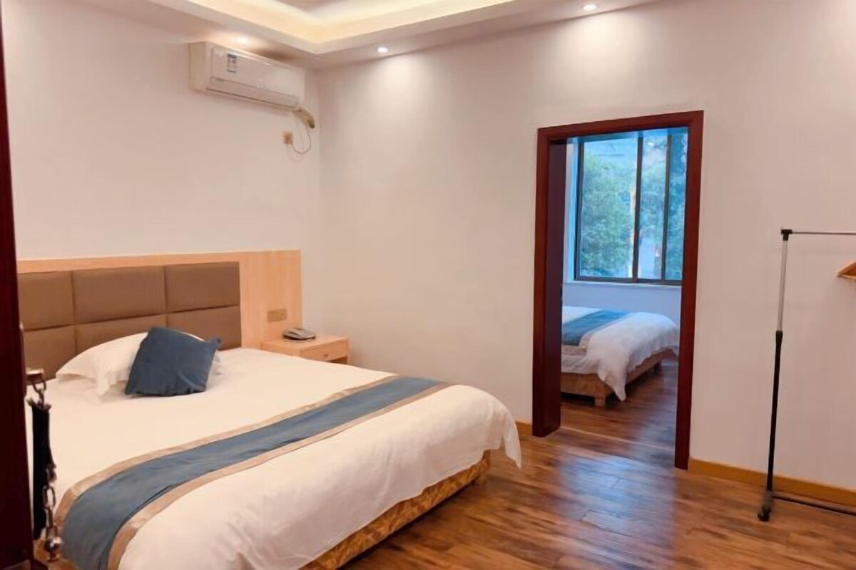 Quarto com cama, mesa de cabeceira e janela.