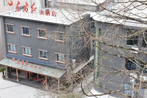 A building with multiple windows and a sign indicating a restaurant. - Jinggangshan Oriental Red Hotel (Jinggangshan City)