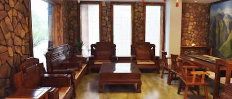 A traditional room with stone walls, wooden furniture, and a painting.