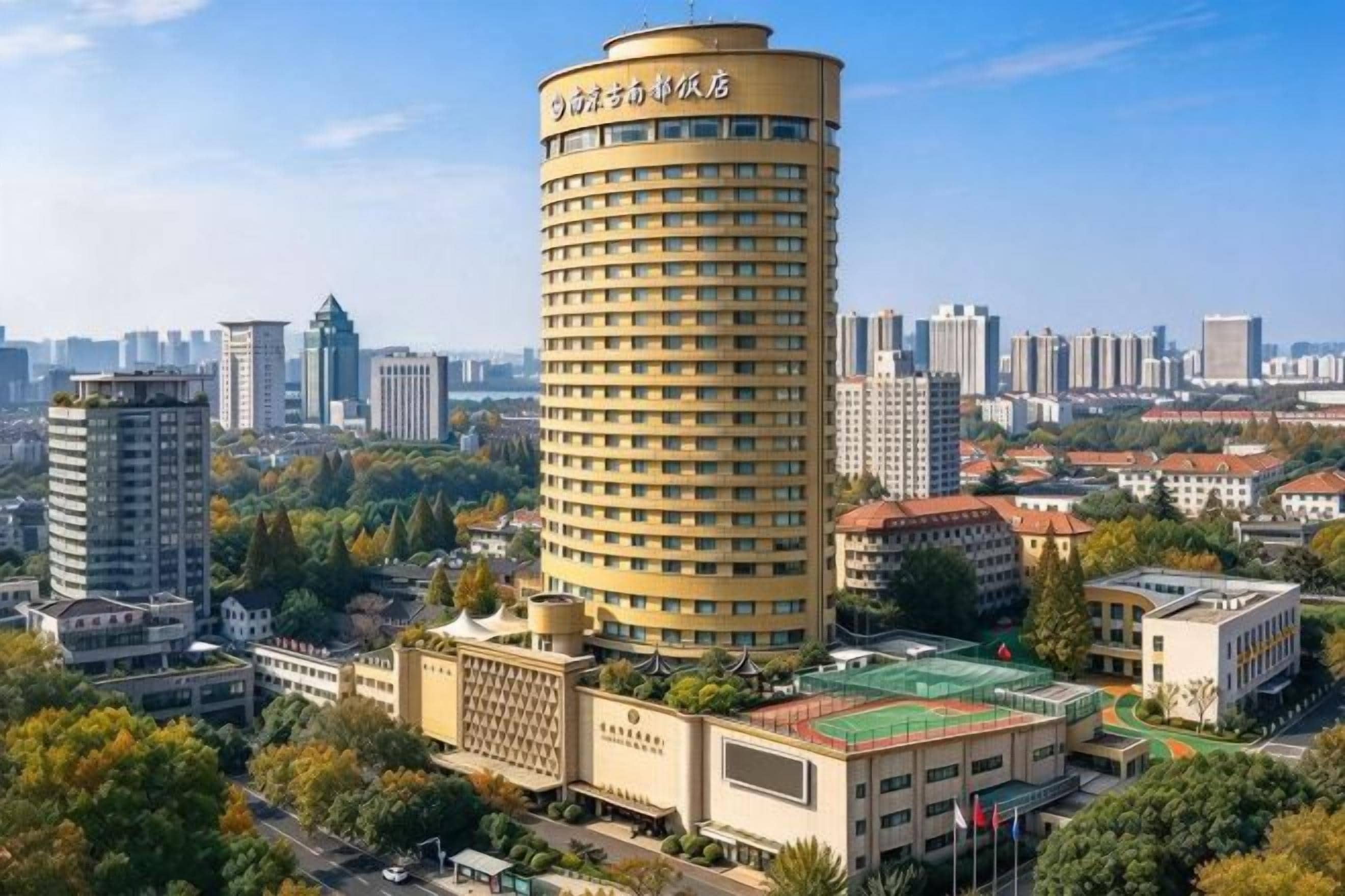 Un grand hôtel de forme cylindrique, entouré d’autres bâtiments et de verdure.