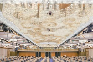 An auditorium with tiered seating and a large, ornate ceiling.