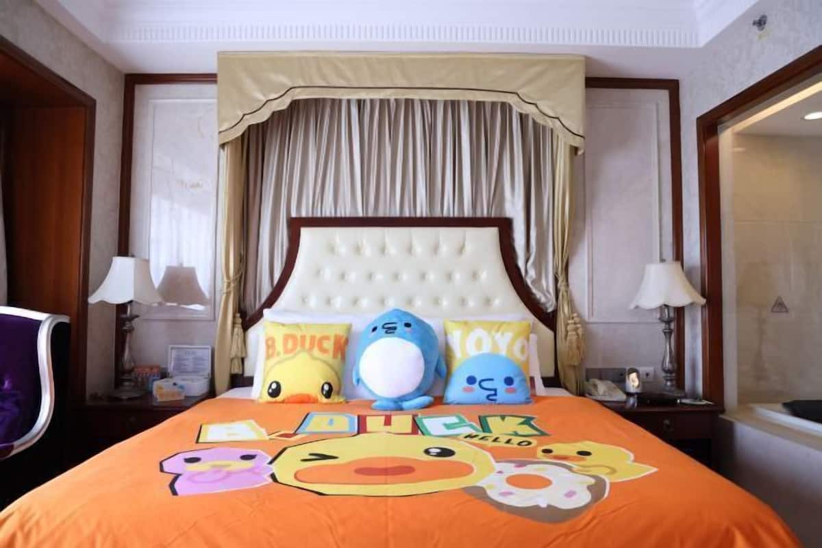 A hotel room with a bed, pillows, and a canopy.