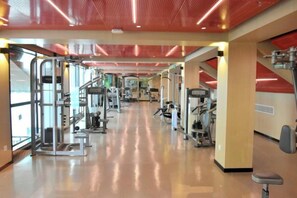 A gym with exercise equipment, a mirrored wall, and a red ceiling. - Nanjing Grand Hotel (Nanjing)