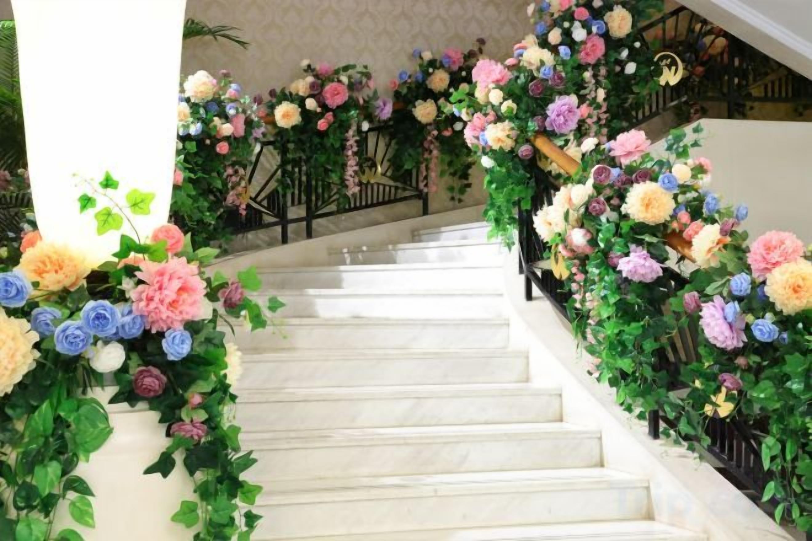 A staircase with white steps and floral decorations on both sides.