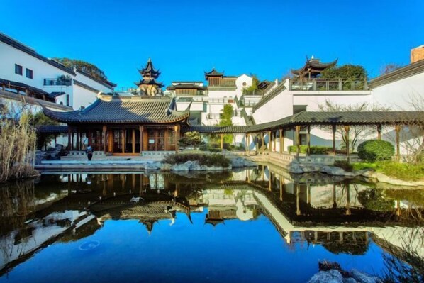 A traditional courtyard with a pond reflecting buildings, a pavilion, and a small bridge. - Nanjing Grand Hotel (Nanjing)